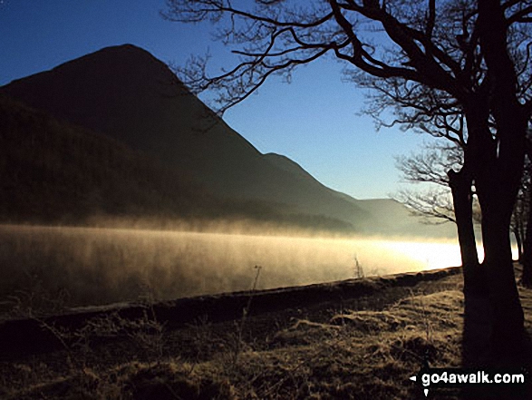 Early morning mist catches the low light on Crummock Water with the towering Grasmoor beyond