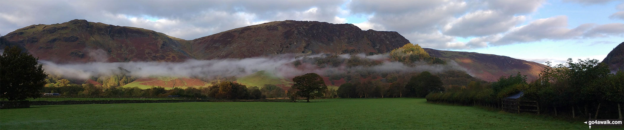 Walk c135 Castle Crag and Rosthwaite from Seatoller (Borrowdale) - Early morning valley mist below Dale Head (Newlands) and High Spy, Maiden Moor & Cat Bells (Catbells) with the summit of Castle Crag (front right) lit by a ray of sunshine from Rosthwaite