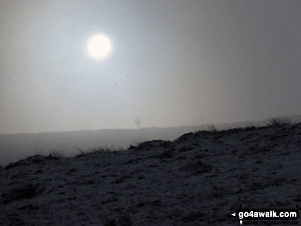 The sun breaking through over a snowy Ilkley Moor 