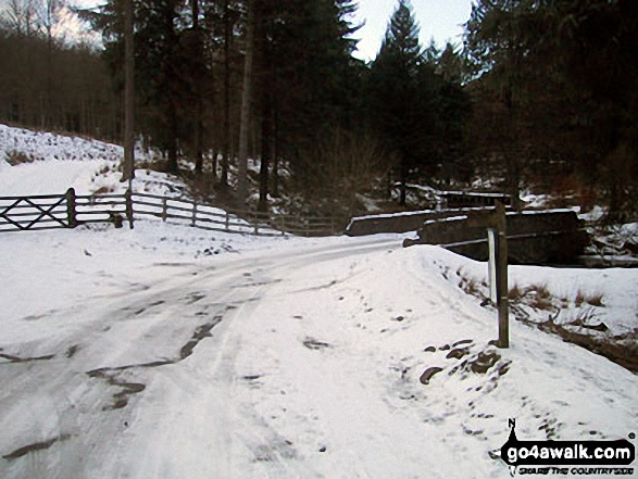 Bridge over Fagney Clough where it enters Derwent Reservoir in the Upper Derwent Valley in the snow 