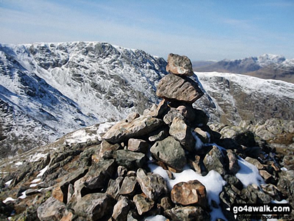 Walk c167 Wetherlam and Swirl How from Low Tilberthwaite - Snow on Black Sails summit cairn with Great Carrs (centre left) and Scafell Pike (far right) in the background