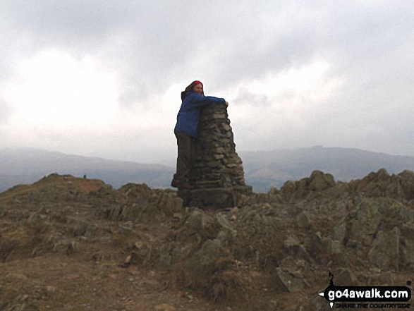 Deb topping out on Loughrigg Fell in The Lake District Cumbria England