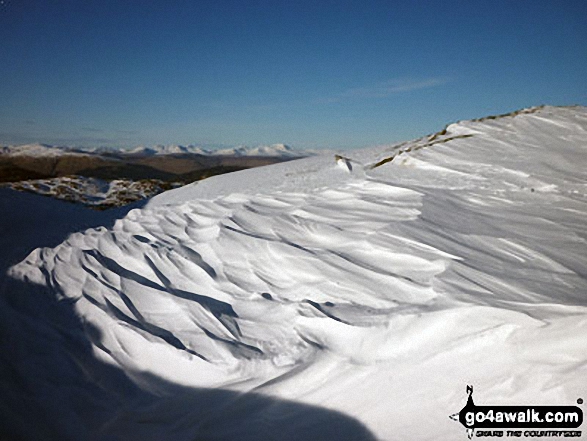 Snow scultured by the wind with the The Lawers range in the distance from Ben Ledi 