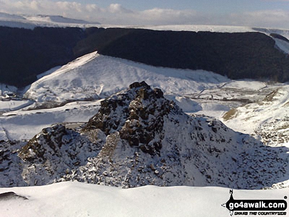 The Tower at Alport Castles in the snow with Kinder Scout in the background 