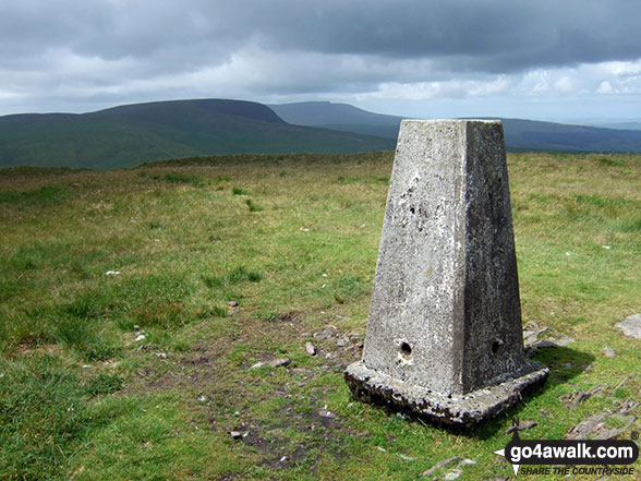 The Fan Nedd Trig Point with Fan Gyhirych beyond, in the mid distance and the Bannau Sir Gaer/Fan Brycheiniog massif in the far distance 