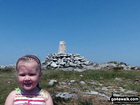 My 4 year old daughter at the trig point on top of Holyhead Mountain This was her first one under her own steam, the start of years of hiking and climbing with luck.