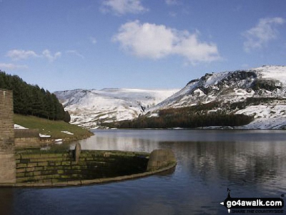 Dove Stone Reservoir overflow with snow on Great Dove Stone Rocks in the distance