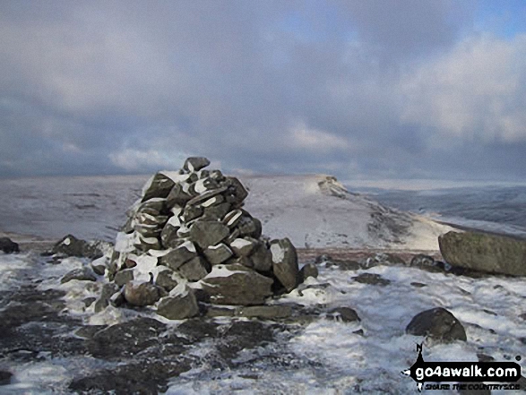 Swarth Fell summit cairn in the snow with Wild Boar Fell in the background 