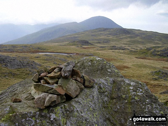 Grey Knotts summit cairn with Great Gable in the distance 