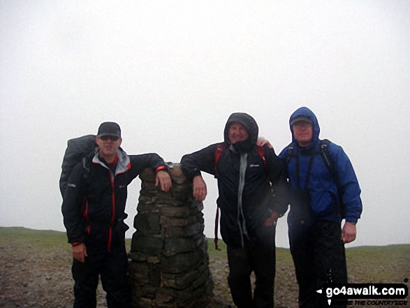 Walk c394 Helvellyn, Catstye Cam and Sheffield Pike from Glenridding - Mike, Tim and Shaun at the summit trig point on a very wet Helvellyn - I swear there were seals on the summit!