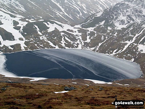 A frozen Grisedale Tarn from the lower slopes of Dollywaggon Pike in the snow 