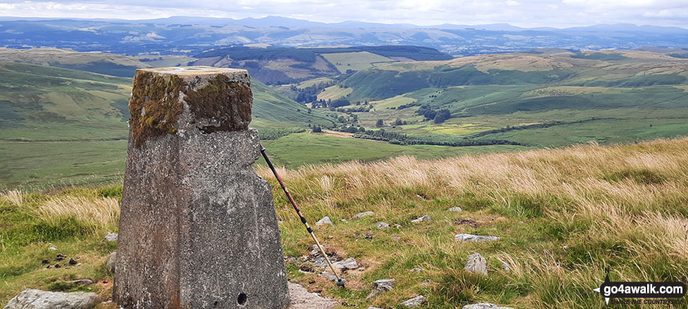 The trig point on the summit of Y Gamriw looking south towards the Brecon Beacons