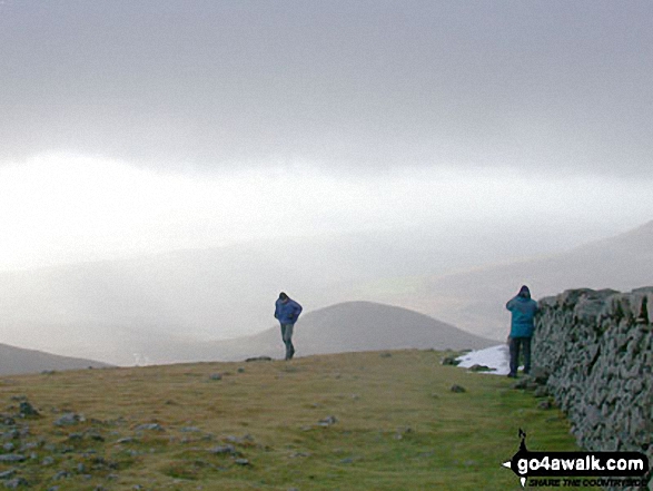 workmates at the summit with snow on Sleive Donnard in The Mournes Down Northern Ireland