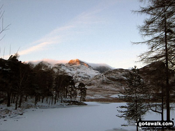 Walk c147 Little Langdale and Great Langdale from Elterwater - The last rays on sunshine on The Langdale Pikes across a frozen Blea Tarn (Langdale)