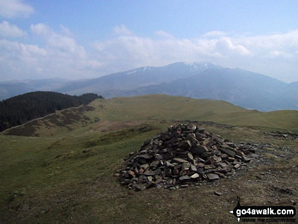 Sale Fell summit cairn with a snow topped Skiddaw looming in the distance 