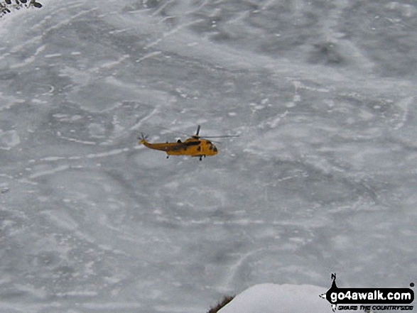 Walk c220 Helvellyn via Striding Edge from Glenridding - Rescue Helicopter above a frozen Red Tarn from Striding Edge