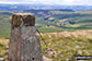 The trig point on the summit of Y Gamriw looking south towards the Brecon Beacons