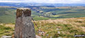 The trig point on the summit of Y Gamriw looking south towards the Brecon Beacons