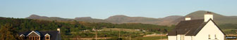 The Rhinogs featuring (left to right): Rhinog Fawr, Rhinog Fach, Y Llethr, Diffwys and Moelfre (Rhinogs) (behind the house) from Llandanwg